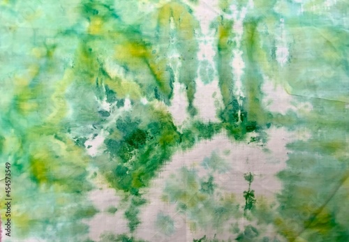 Knotted batik. Beautiful watercolor stains. Abstract painting. Paint runs on the fabric. Merging colors.