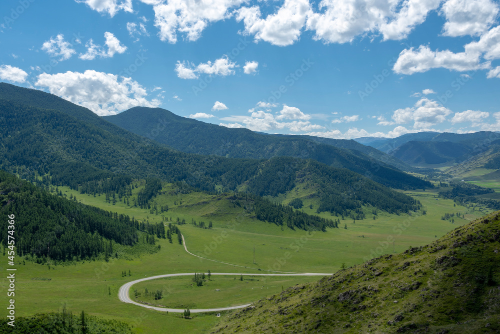 winding highway climbing a mountain pass on a summer day