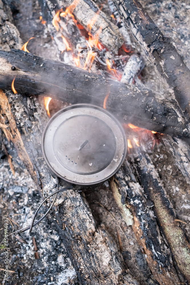 Pot of preparing food stands on the coals campfire, camp, summer day. Top view. Pot of preparing food stands on the coals campfire, camp, summer day. Top view.