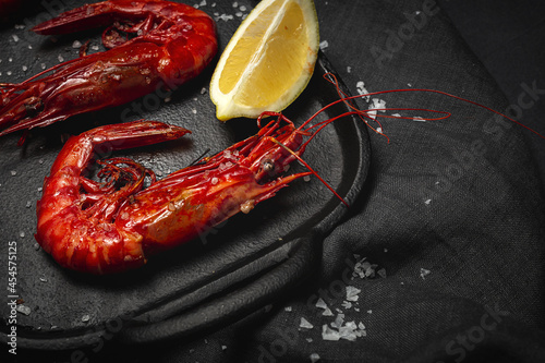 Scarlet shrimps with fresh lemon slices on tray photo