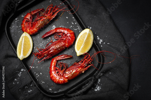 Scarlet shrimps with fresh lemon slices on tray photo