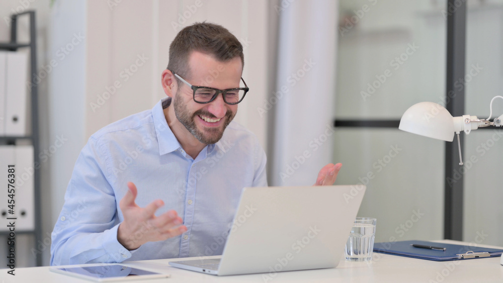Fototapeta premium Middle Aged Man Celebrating Success while using Laptop 