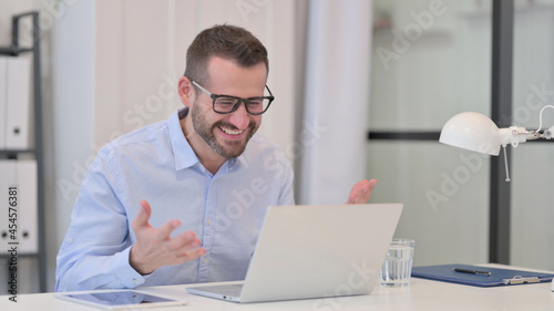 Middle Aged Man Celebrating Success while using Laptop 