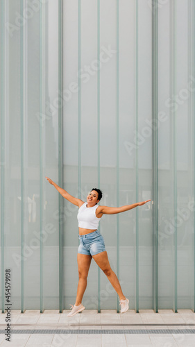 Fototapeta Naklejka Na Ścianę i Meble -  Young mixed race woman outdoor jumping celebrating success feeling free - 16:9 cropped banner