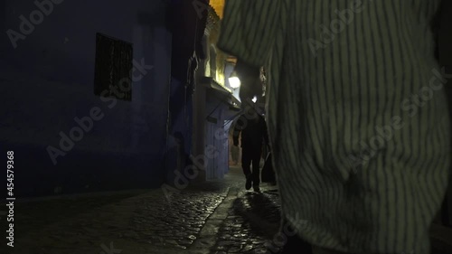 Persona caminando en la oscuridad de la noche en la ciudad de Chefchaouen en Marruecos
