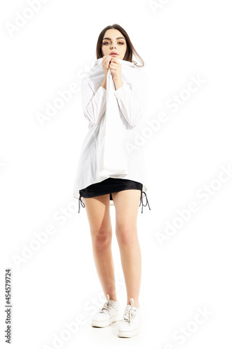 Shivering trembling young woman in black dress and white shirt squeezing feeling cold. Full body portrait isolated on white background