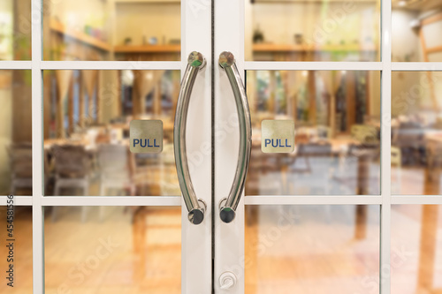 Restaurang door handle with pull sign on glass doors