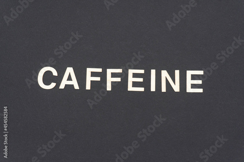 CAFFEINE word written on dark paper background. CAFFEINE text for your concepts