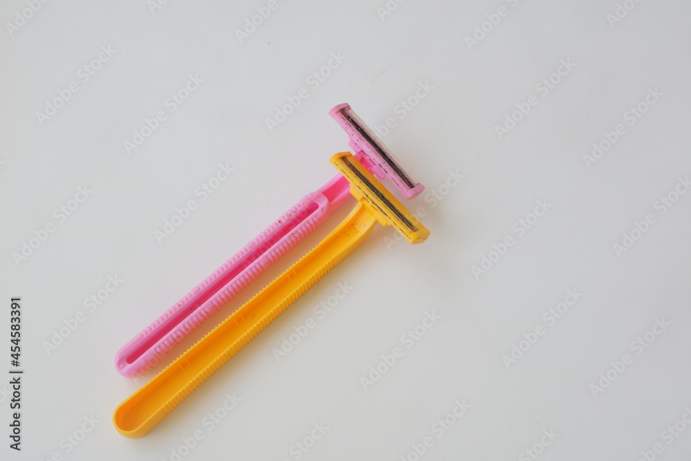 used pink and yellow beard razor on white isolated background used pink and yellow beard razor on white isolated background