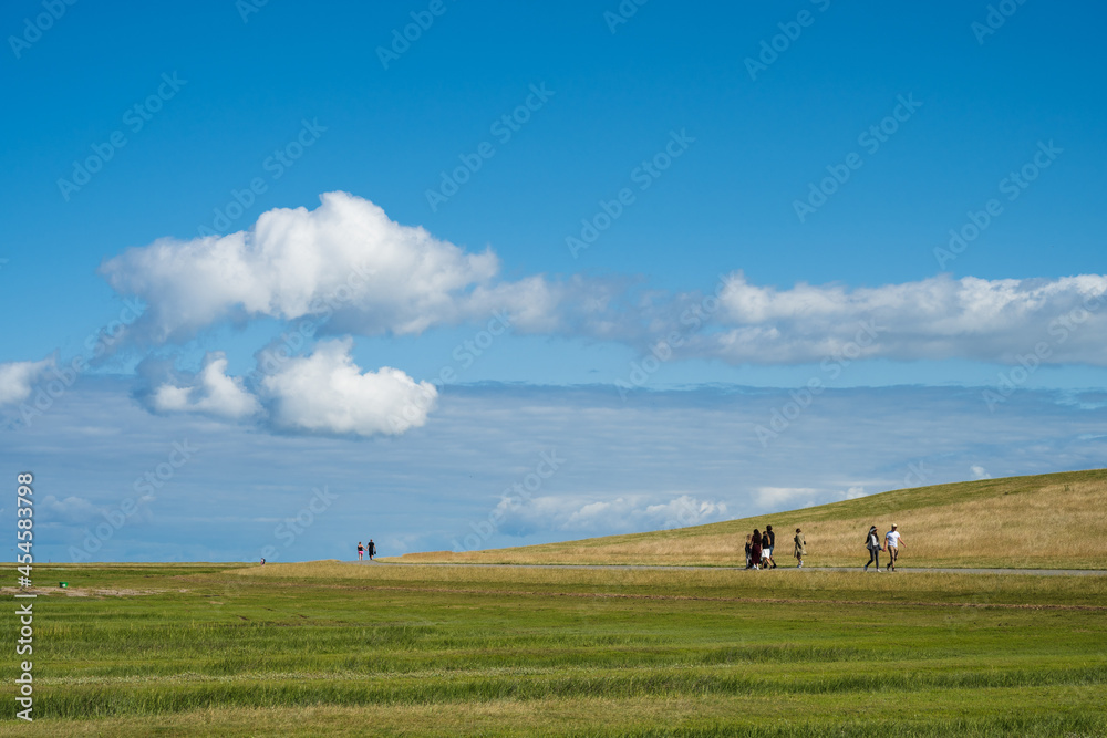 Spaziergänger am Deich auf der Halbinsel Eiderstedt Spaziergänger am Deich auf der Halbinsel Eiderstedt