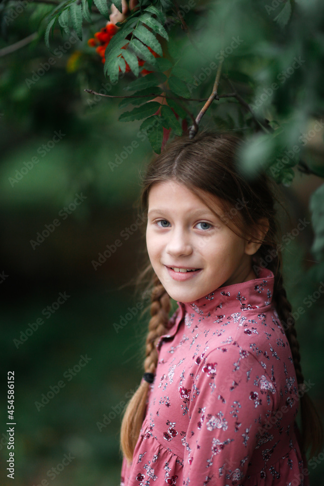 Cute caucasian child girl in a dress collects rowan berries in a natural wicker basket, natural products and vitamins, natural materials for creativity Cute caucasian child girl in a dress collects rowan berries in a natural wicker basket, natural products and vitamins, natural materials for creativity