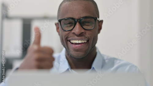 Fototapeta Naklejka Na Ścianę i Meble -  Close Up of African Man Doing Thumbs up with Laptop 