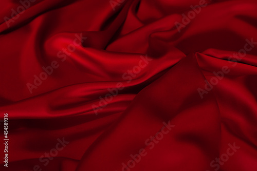 Red fabric texture background. Silk satin folds
