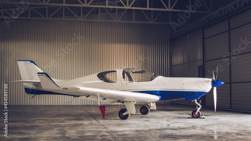 Small white private jet parked in the hangar