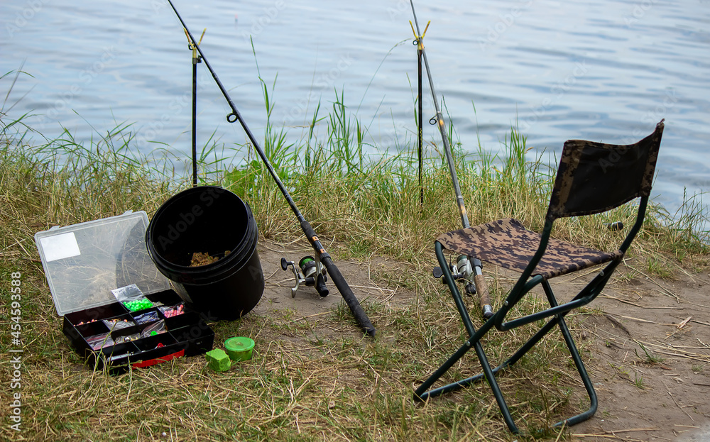 Fishing tackle on the river bank, bait rod, spinning rod, fish