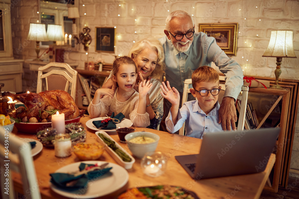 Happy grandparents with grandkids make video call on Thanksgiving at home.