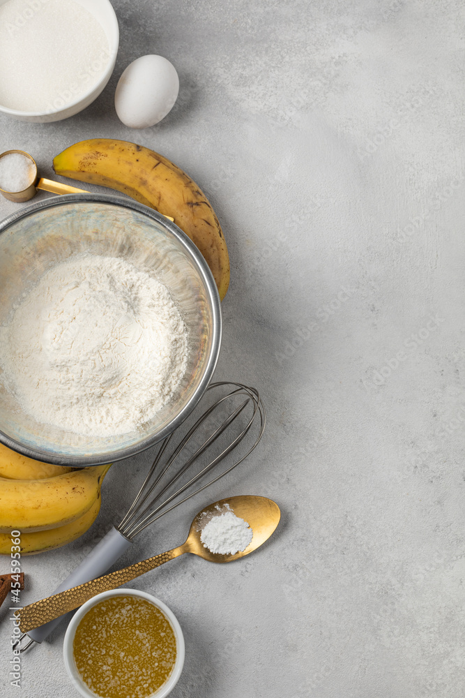 Ingredients for banana bread in bowls on light gray background top view Ingredients for banana bread in bowls on light gray background top view