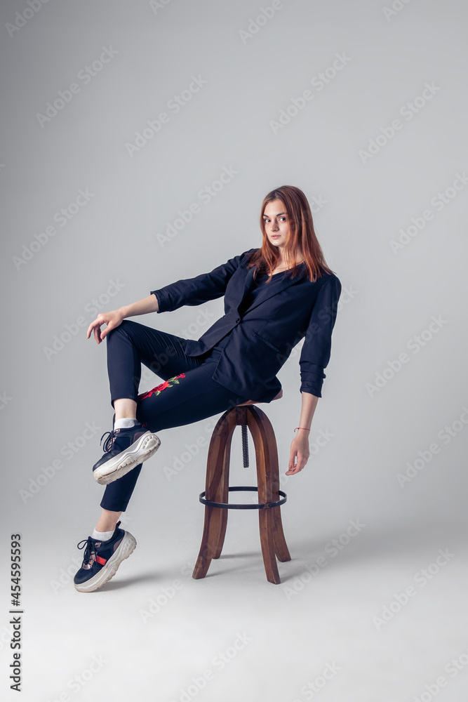 Fototapeta premium a red-haired girl is sitting on a chair