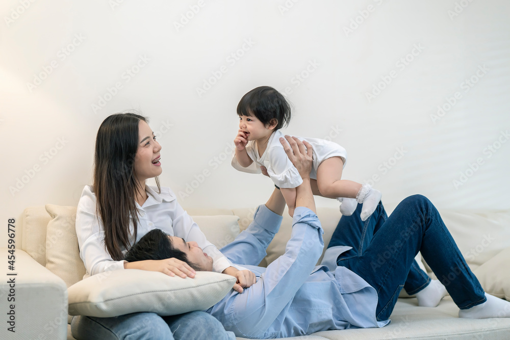 Asian Parents and a kid child playing at home. Family concept.