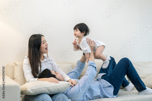 Asian Parents and a kid child playing at home. Family concept.
