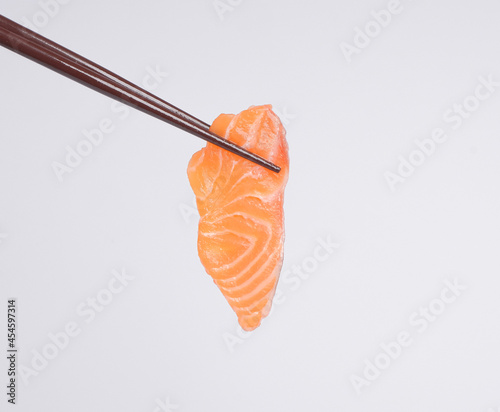 Salmon sashimi using chopsticks, ready to eat.