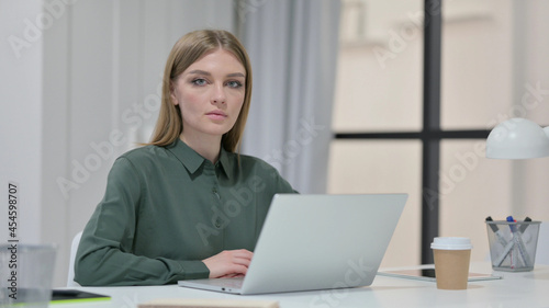 Young Woman with Laptop Looking at Camera 