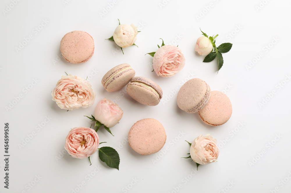 Flat lay composition with pink macarons and roses on white background Flat lay composition with pink macarons and roses on white background