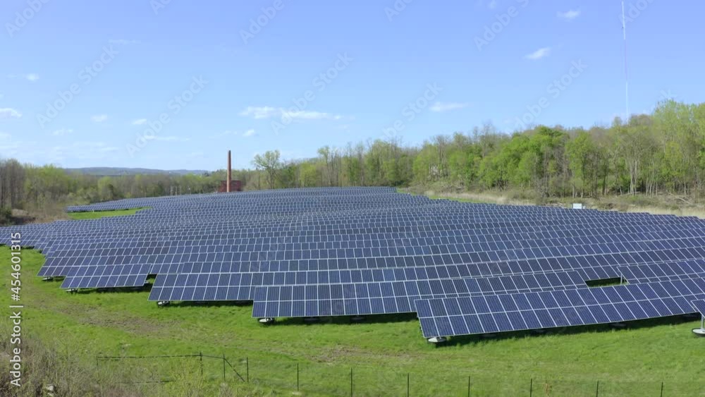 Slow rise reveals solar farm in a field surrounded by trees Slow rise reveals solar farm in a field surrounded by trees