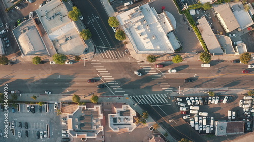 City traffic at sunset. Busy street in the city center. Cars cross the intersection. The camera looks down from a bird's eye view. Drone footage.