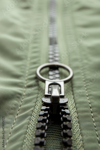 Metal zipper on nylon texture, closeup or macro view. Fastener on jacket  photo