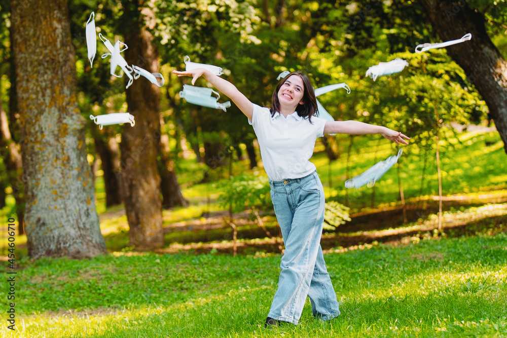 Close up photo of a happy young woman activist being outdoors throwing the medical masks and protesting over pollution and global warming. Close up photo of a happy young woman activist being outdoors throwing the medical masks and protesting over pollution and global warming.
