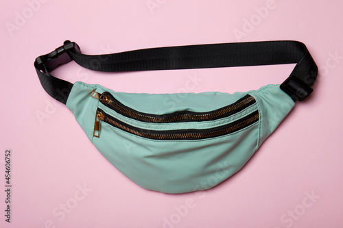 Fototapeta Naklejka Na Ścianę i Meble -  Belt bag on pink background. Top view of casual waist bag