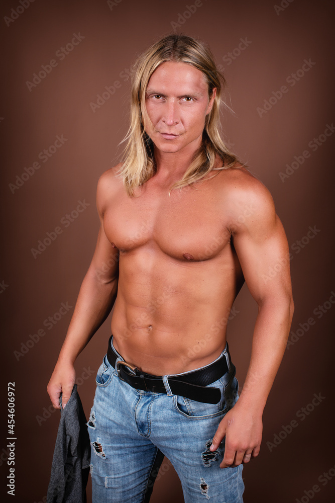 Handsome athletic man on a brown background. Handsome athletic man on a brown background.