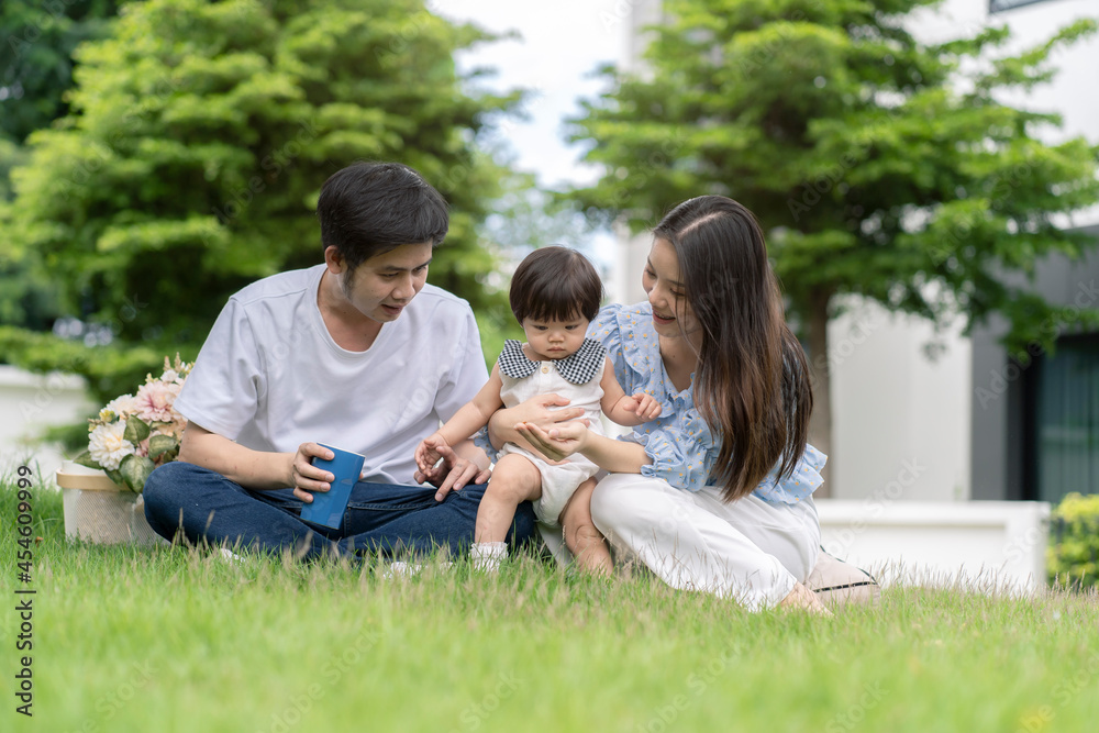 Asian Parents and a kid child playing in the garden at home. Family concept. Asian Parents and a kid child playing in the garden at home. Family concept.