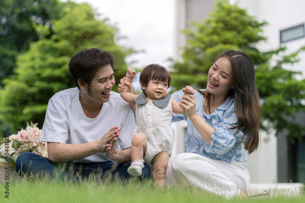 Asian Parents and a kid child playing in the garden at home. Family concept.