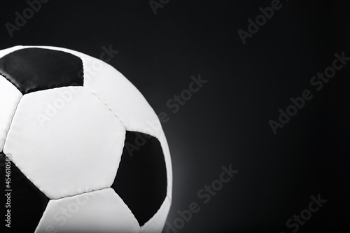 Football ball on black background, closeup. Space for text