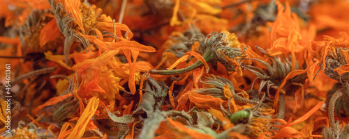 A scattering of dried orange flowers of medicinal calendula close up