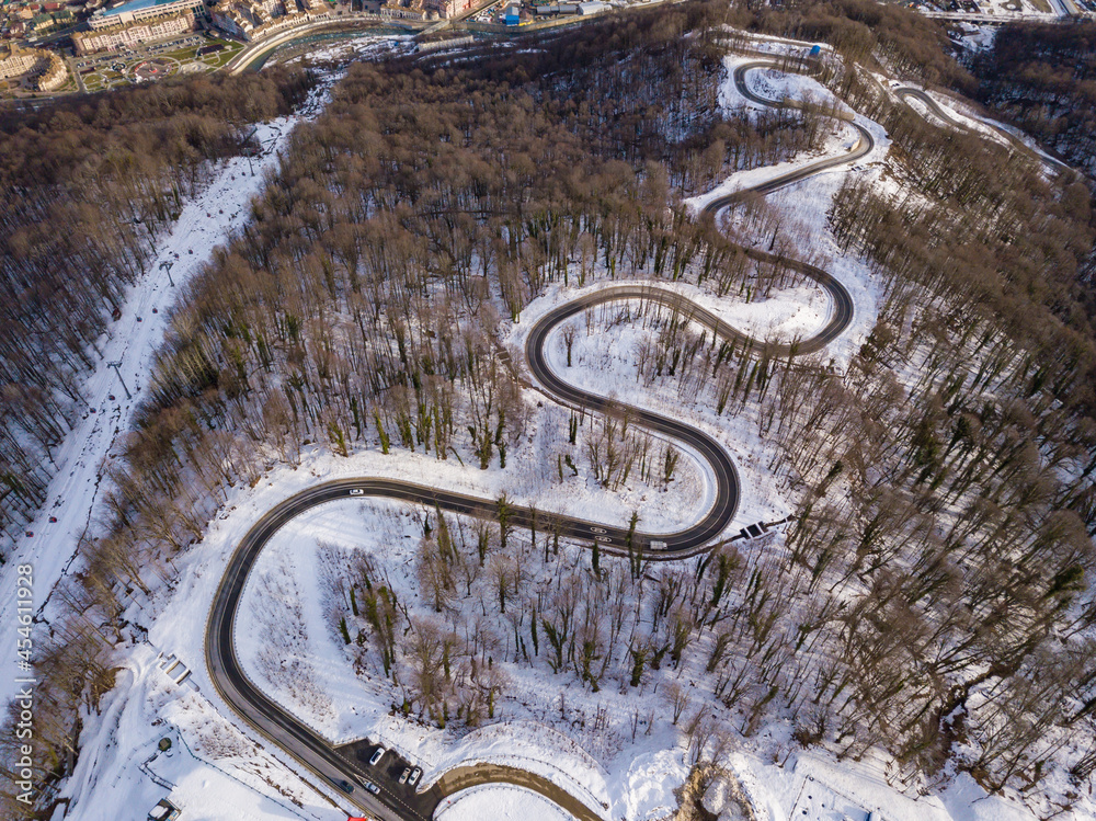 Winter aerial view of the road to ski resort Krasnaya Polyana. Beautiful winter landscape from drone.