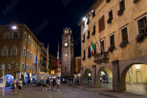 Riva del Garda, Italy, 08-23-2021: The city tower Torre Apponale in the evening with lighting and tourists
