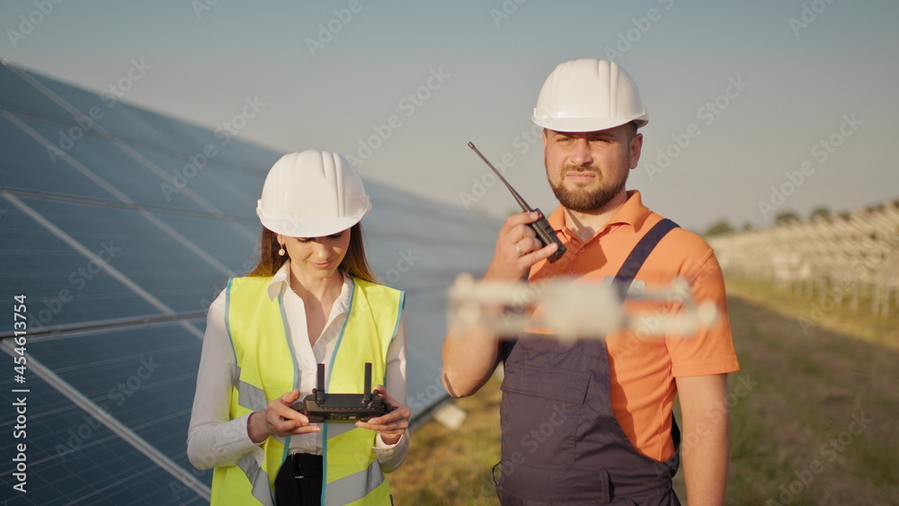 Portrait of a female engineer operating a drone on the background of a solar power plant. Photovoltaic solar panel installation. Solar array. New technologies. Investor and worker engineer Portrait of a female engineer operating a drone on the background of a solar power plant. Photovoltaic solar panel installation. Solar array. New technologies. Investor and worker engineer