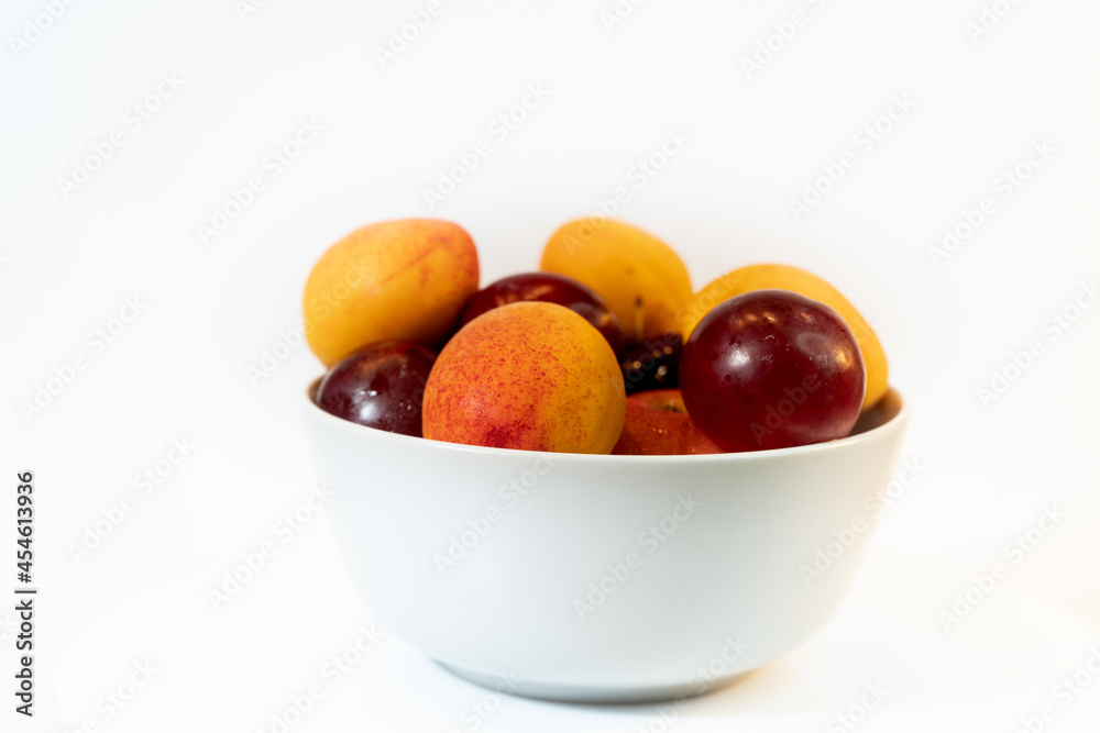 Fruit in a plain light bowl on a plain surface. Healthy vegetarian food Fruit in a plain light bowl on a plain surface. Healthy vegetarian food