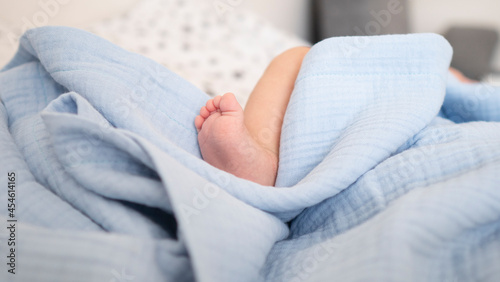 Foto Baby's foot in pastel blue cotton muslin blanket