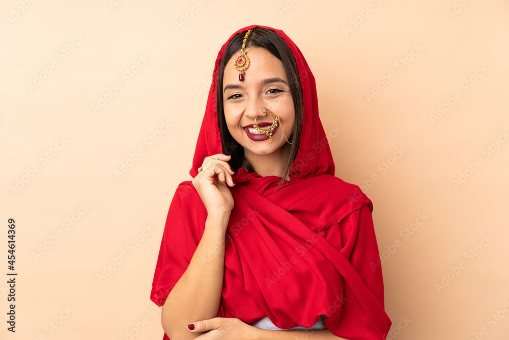 Young Indian woman isolated on beige background laughing Young Indian woman isolated on beige background laughing