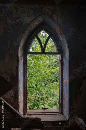 Ogival window in old ruined abandoned historical mansion in Gothic style