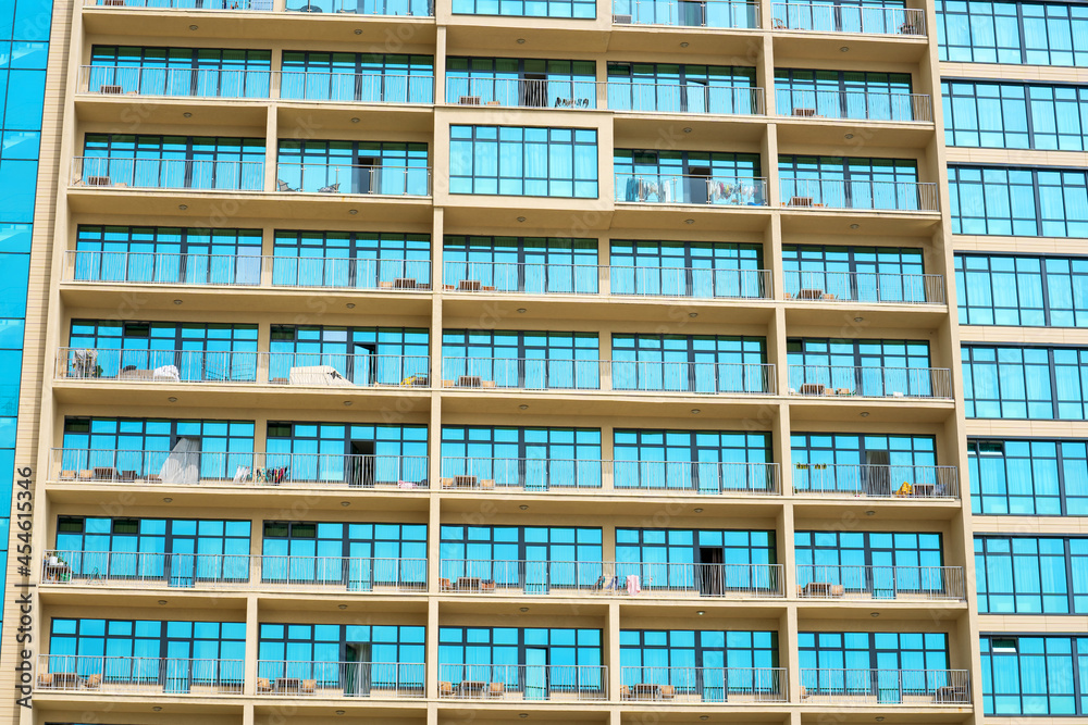 The facade of a high-rise building with balconies and blue windows The facade of a high-rise building with balconies and blue windows