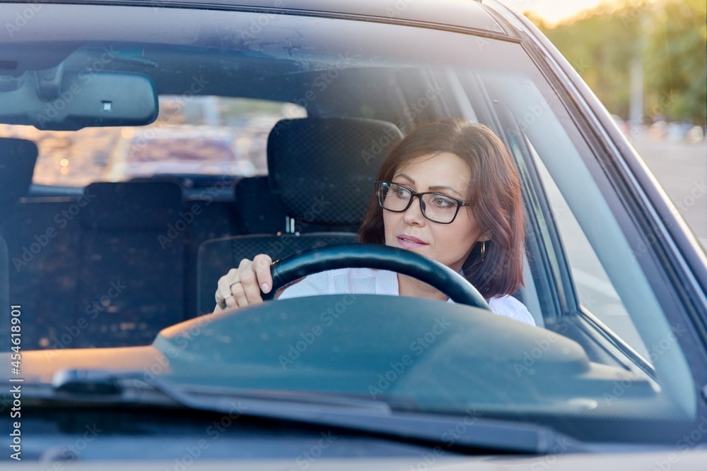 Middle-aged woman driver with glasses, female driving a car. Middle-aged woman driver with glasses, female driving a car.