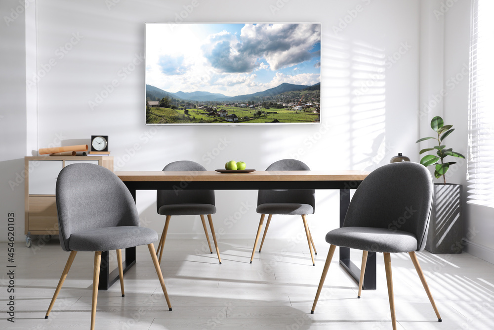 Fototapeta premium Modern wide screen TV on white wall in room with stylish furniture