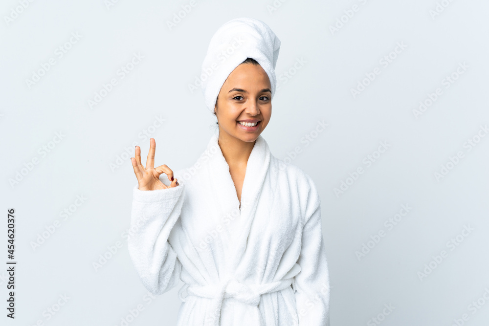 Young woman in bathrobe over isolated white background showing ok sign with fingers Young woman in bathrobe over isolated white background showing ok sign with fingers