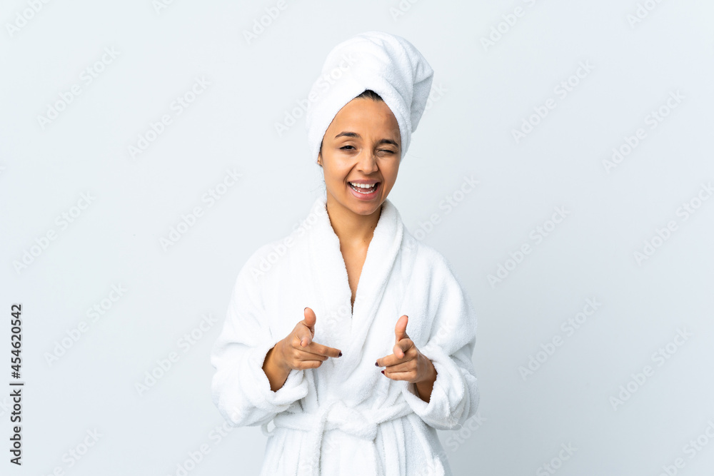 Young woman in bathrobe over isolated white background pointing to the front and smiling Young woman in bathrobe over isolated white background pointing to the front and smiling