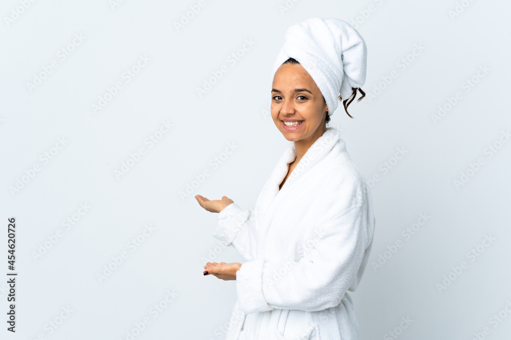 Young woman in bathrobe over isolated white background extending hands to the side for inviting to come Young woman in bathrobe over isolated white background extending hands to the side for inviting to come